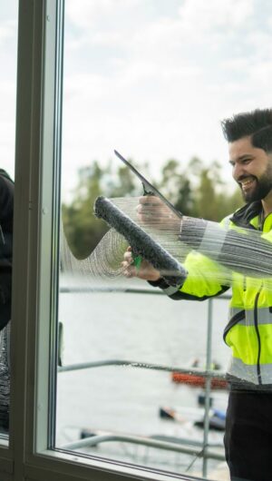 Man cleaning a bright living room window